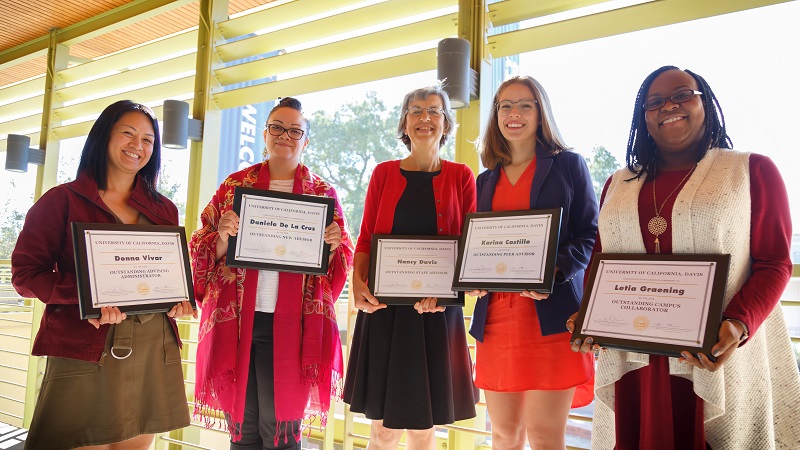 Award recipients holding framed awards.