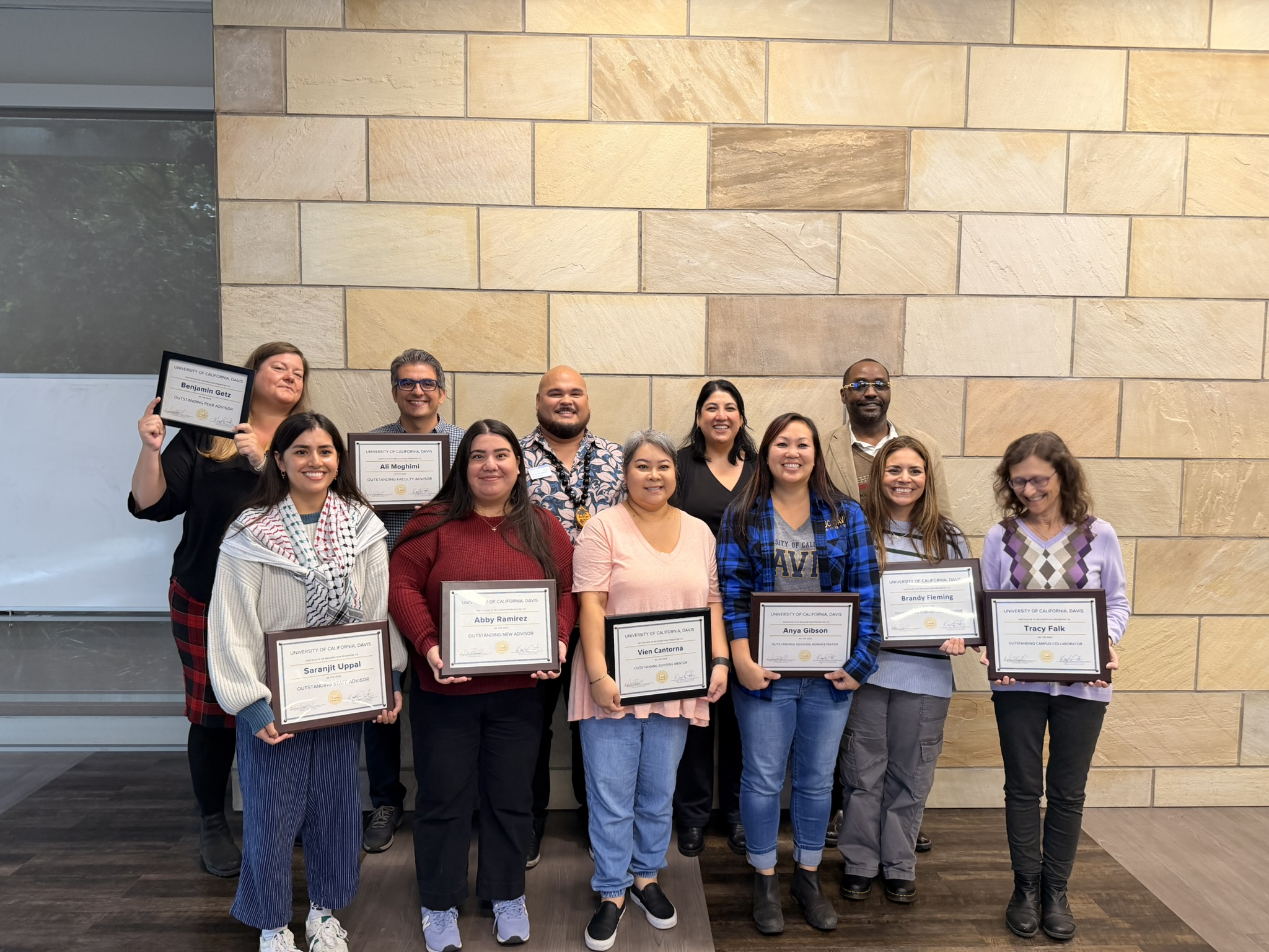 This year's award recipients in a group holding award plaques.