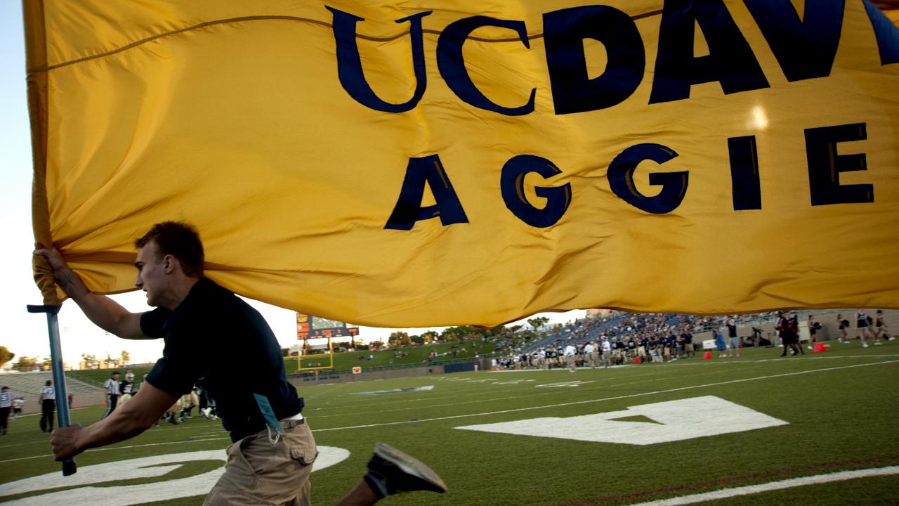 UC Davis Aggies flag held by runner.