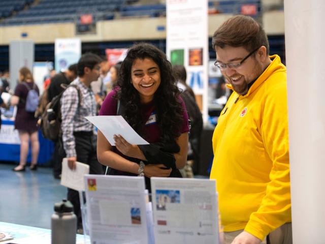 Student at career fair chats with a potential employer.
